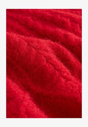 Tessuto lavorato a maglia rosso con una texture pelosa, che presenta un pattern di punti rialzati e diverse dimensioni superficiali.