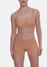 Tanskleurige seamless bralette met dunne bandjes en bijpassende boyshorts. Zachte, gladde textuur, aansluitend ontwerp en geen zichtbare naden voor extra comfort.
