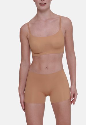 Tanskleurige seamless bralette met dunne bandjes en bijpassende boyshorts. Zachte, gladde textuur, aansluitend ontwerp en geen zichtbare naden voor extra comfort.