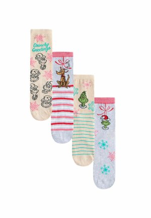 Quatre paires de chaussettes sur le thème des fêtes : crème avec des graphiques du Grinch, gris avec des rayures rouges et des rennes, rayées vertes, et gris clair avec des flocons de neige.