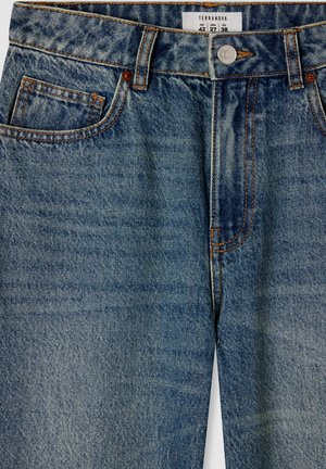 Jeans in denim blu con vestibilità regolare. Presentano cinque tasche, cuciture a contrasto, chiusura con bottoni metallici e un'etichetta sulla cintura.