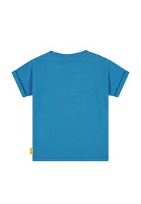 Camiseta de algodón azul de manga corta con cuello redondo, que presenta puños enrollados y una pequeña etiqueta amarilla en el lado inferior.