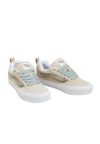 Sneakers in suede beige con lacci azzurri chiari e dettagli color sabbia. Presentano una suola in gomma bianca e una patch con logo sulla linguetta.