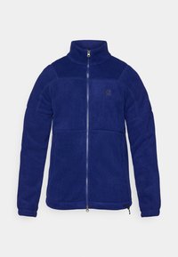 Chaqueta de forro polar azul marino con cuello alto, cremallera frontal completa y un logotipo en el pecho. Presenta una textura suave y costuras en contraste.