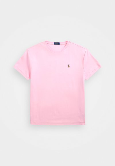 T-shirt de algodão rosa com mangas curtas, decote redondo e pequeno logotipo bordado no lado esquerdo do peito. Textura suave, ajuste casual.