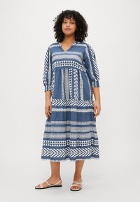Abito midi blu e bianco con motivo, scollatura a V, maniche 3/4, vita arricciata e design geometrici. Tessuto liscio con una vestibilità comoda.
