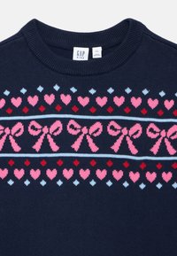 Μπλε πλεκτό πουλόβερ με στρογγυλό γιακά, διακοσμημένο με σχέδιο από ροζ φιόγκους και καρδιές, τονισμένο με ανοιχτό μπλε και κόκινες λεπτομέρειες.