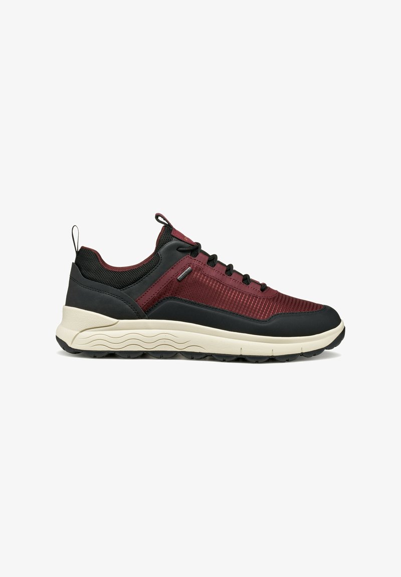 Sneaker bassa con tomaia in rete bordeaux, dettagli neri, suola bianca ondulata, lacci neri e linguetta e pull tab sul tallone.