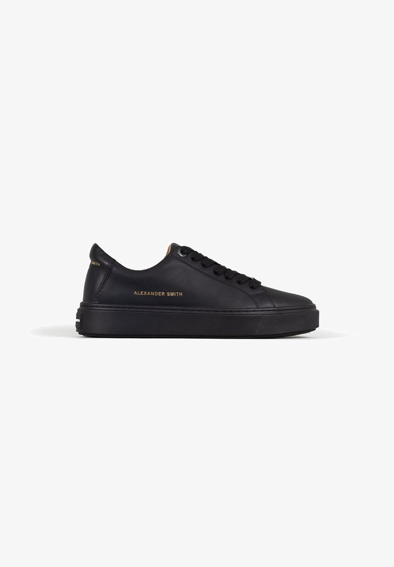 Sneaker in pelle nera con punta arrotondata, suola piatta e design con lacci. Presenta il marchio "Alexander Smith" in oro sul lato.