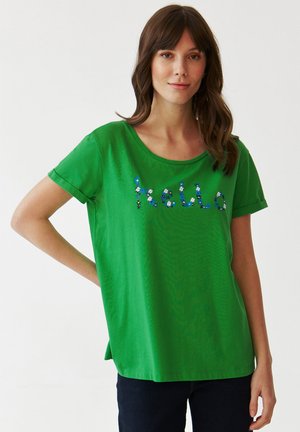 Groene t-shirt met korte mouwen, voorzien van een ontspannen halslijn en bloemenversieringen die "hello" spellen. Gemaakt van zachte katoen.