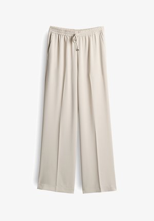 Pantaloni a gamba larga beige realizzati in un tessuto leggero e morbido. Presentano una vita elasticizzata con coulisse e tasche laterali.
