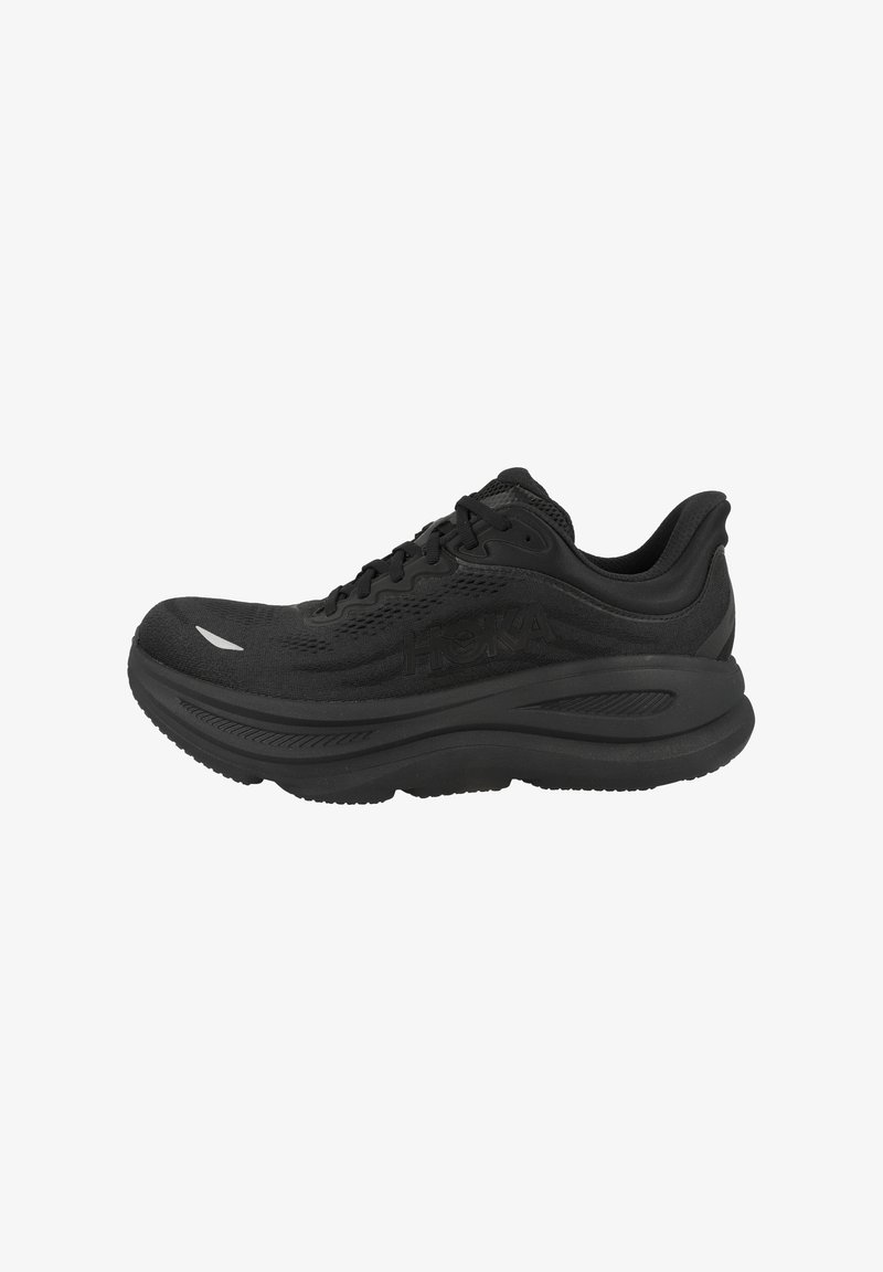 Baskets de course noires avec une tige en mesh, semelle intermédiaire rembourrée, semelle texturée et talon renforcé, présentant un logo ton sur ton sur le côté.