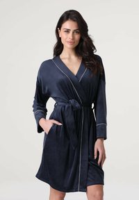 Accappatoio blu navy realizzato in morbido tessuto, con design avvolgente, rifiniture bianche, maniche lunghe e vita con lacci, dotato di tasche.