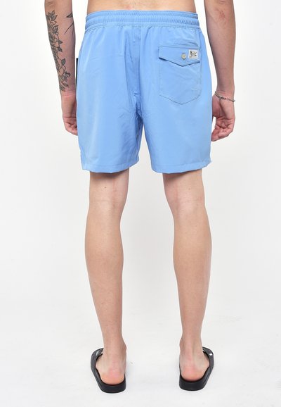 Pantaloni da nuoto blu realizzati in materiale leggero, con una tasca sul retro e una vita elastica, di colore uniforme e senza motivi visibili.