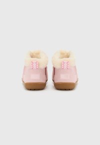 Bottes en daim rose avec doublure en fausse fourrure, semelles en caoutchouc et détail de couture en zigzag. Talon carré et texture douce.
