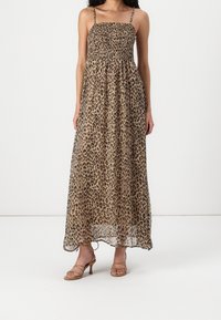 Maxi dress with leopard print in beige and black. Features smocked bodice, thin shoulder straps, and flowing, lightweight fabric.