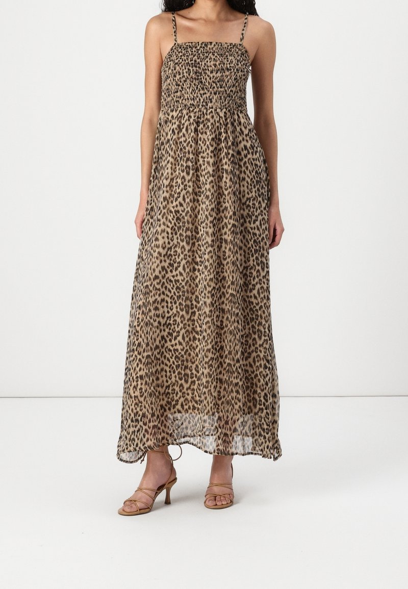 Maxi dress with leopard print in beige and black. Features smocked bodice, thin shoulder straps, and flowing, lightweight fabric.