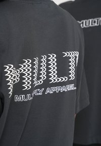 Sort t-shirt med hvid tekst "MULTI" med bølgemønstre og "MULTIPLY APPAREL" nedenfor. Korte ærmer og afslappet pasform.