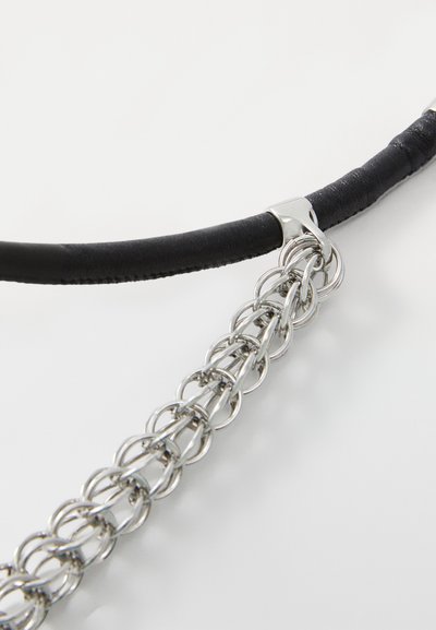 Black faux leather strap with a silver-tone metal chain, featuring intertwined circular links and a smooth textural finish.