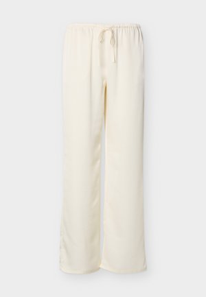 Kreemivärvilised lahedalt istuvad püksid elastse vöökohaga ja nööriga, laotatud tasapinnale heledal taustal.