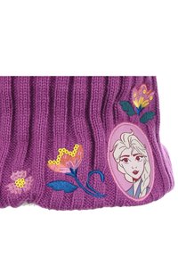 Cappello lavorato a maglia viola con texture a costine, decorazioni floreali ricamate e un ritratto di un personaggio su una toppa circolare.