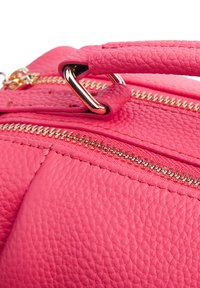 Borsa in pelle texturizzata rosa con hardware dorato, dotata di chiusura a zip, manico prominente e dettagli di cucitura visibili.