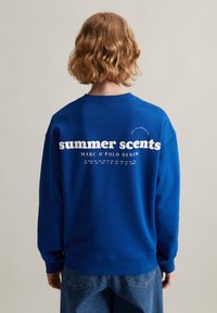 Blauwe sweatshirt van katoen met ronde hals, voorzien van witte tekst "zomergeuren" en "MARC O'POLO DENIM" gedrukt op de rug.