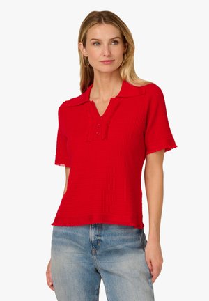 Red short-sleeve polo shirt with a textured knit fabric, collar, five-button placket, and fringe detailing along the hem and sleeves.