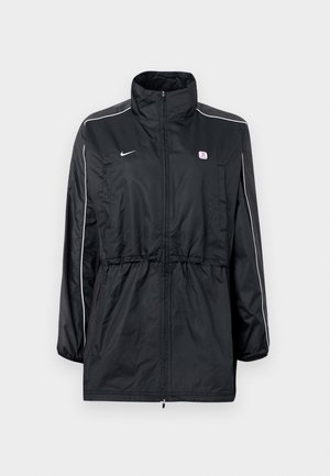 Černá větrovka s vysokým límcem, zapínáním na zip, nastavitelným stahováním v pase a bílými bočními pruhy. Logo na hrudi.