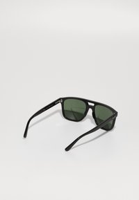Ochelari de soare negri cu lentile verzi, de formă rectangulară și cu rame din plastic neted. Au un logo pe braț și brațe subțiri.
