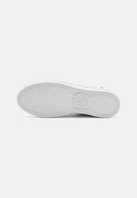 White rubber sneaker sole with textured pattern and logo in the center. Smooth edges and slight curve for ergonomic shape.