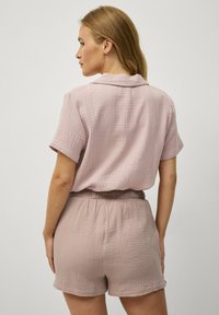 Korte mouwen, geklede outfit in lichtroze textuurstof. Kenmerkt een ontspannen pasvorm met een elastische tailleband en een comfortabele korte lengte.