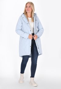 Svijetloplavi vodootporni parka s kapuljačom na vezanje, dugmadi na snap i džepovima na patentni zatvarač. Dugi rukavi i model srednje dužine.