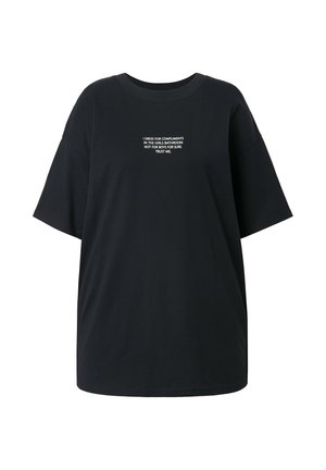 Schwarzes, übergroßes T-Shirt aus Baumwolle mit Rundhalsausschnitt und kurzen Ärmeln. Auf der Vorderseite in Weiß der Text: "ICH KLEIDE MICH FÜR KOMPLIMENTE..."