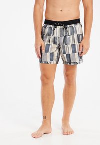 Bañadores de hombre con un patrón geométrico de rectángulos y óvalos. Los colores incluyen marino, gris y beige. Cintura elástica con cordón ajustable.
