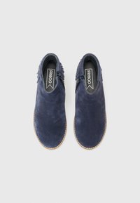 Chaussures en suède bleu marine avec une texture lisse, à bout rond et semelle cousue beige. Présentent des accents nervurés sur les côtés.