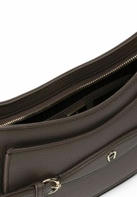 Sac à main en cuir marron avec une finition texturée, doté d'une fermeture éclair et de subtils accents en métal doré. L'intérieur présente des compartiments supplémentaires.