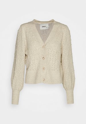 Beige gebreide cardigan met een diamantpatroon, parelversieringen, V-hals en een geribde zoom met knoopsluiting. Lange puffmouwen.
