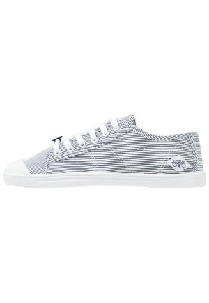 Canvas sneakers in blauw en witte strepen met witte rubberen zolen en veters, met een logo in een rondeaccent op de hiel.