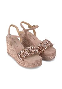 Las sandalias cuña en oro rosa cuentan con una parte superior de ante beige texturizado, una tira con cuentas y una plataforma de esparto tejida. Incluye una correa ajustable para el tobillo.