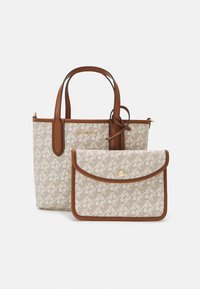 Vaalea beige ja ruskea Michael Kors laukku, jossa on nahkakahvat ja siihen sopiva pieni pussi napilla, molemmissa on logoprintti.