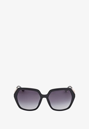 Gafas de sol hexagonales negras con lentes degradados, con una montura de plástico suave y detalles metálicos en la varilla.