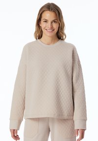 Lichtbeige gewatteerde sweatshirt met lange mouwen en een ronde hals. Heeft een gestructureerd patroon en geribde manchetten. Casual fit.