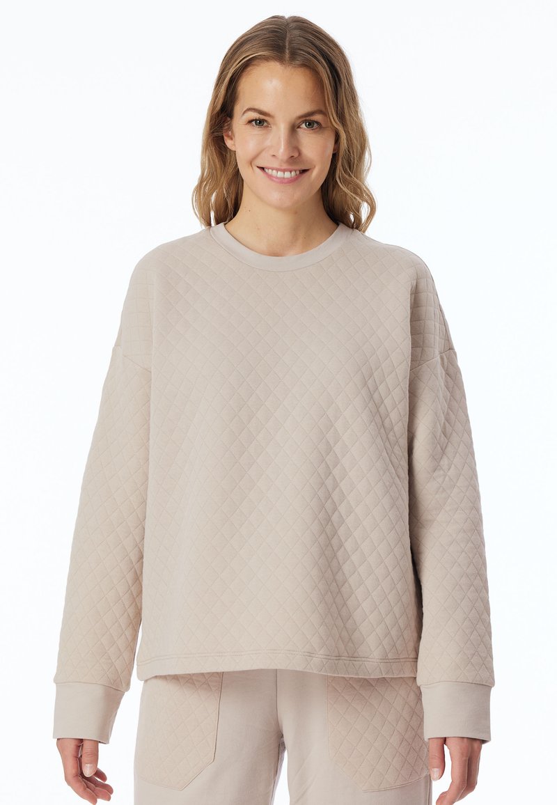Lichtbeige gewatteerde sweatshirt met lange mouwen en een ronde hals. Heeft een gestructureerd patroon en geribde manchetten. Casual fit.