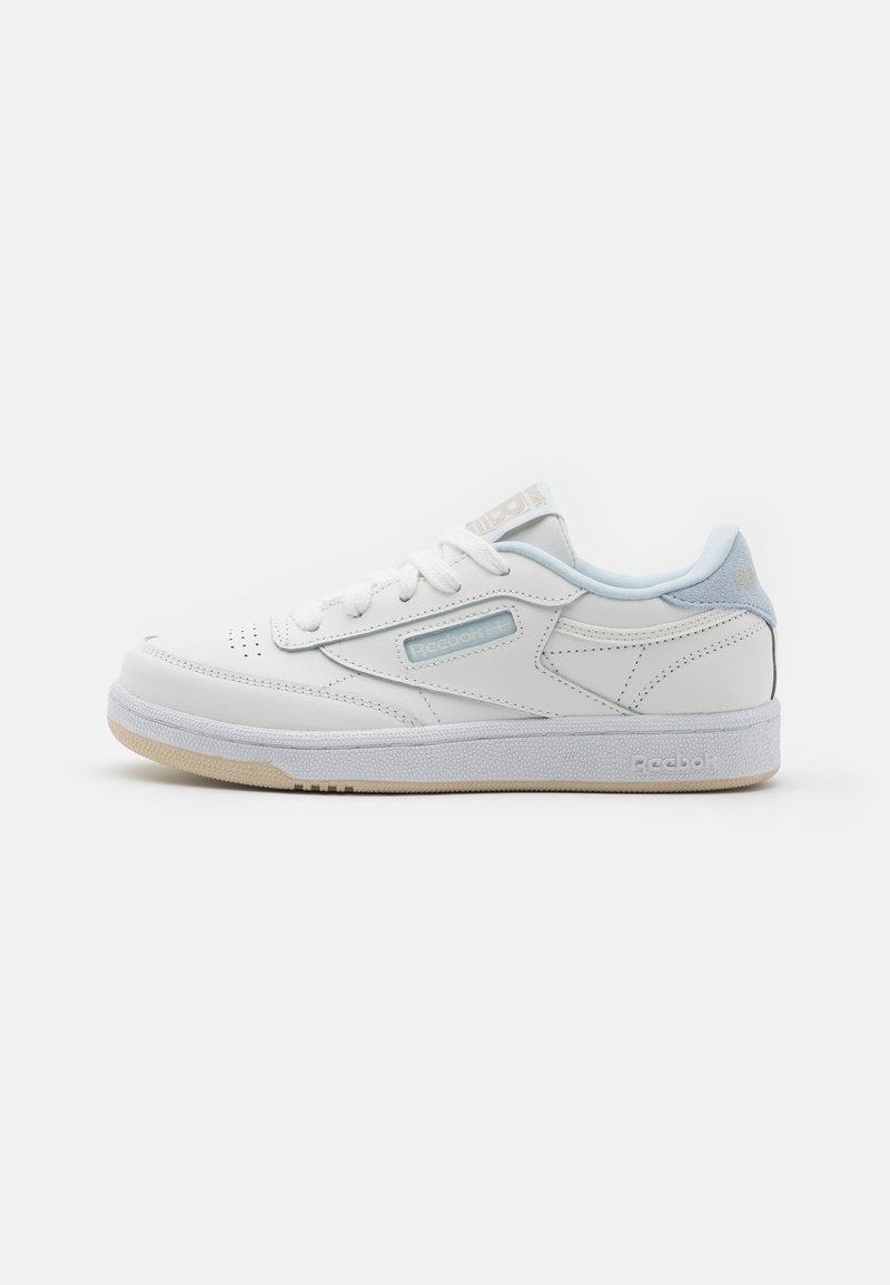 Baskets Reebok basses blanches avec des accents bleu clair, fermeture à lacets et semelle en caoutchouc sur un fond blanc uni.
