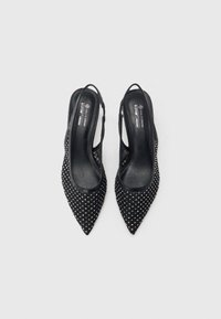 Černé sandálky na vysokém podpatku s otevřenou patou a špičatou špičkou, texturovaný materiál pokrytý kovovými cvočky a hladká černá vnitřní podšívka. Vegan materiál.