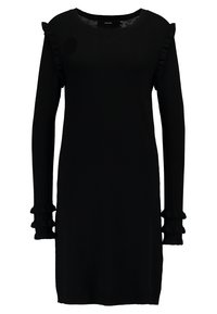En svart långärmad klänning i mjukt stickat material, med volangdetaljer vid axlarna och manschetterna, samt en rund halsringning.
