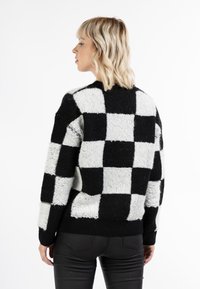 Schwarz-weißer kariertes Sweatshirt mit flauschiger Textur, gerippten Bündchen und Saum, in einem Boxy-Schnitt und mit Rundhalsausschnitt.