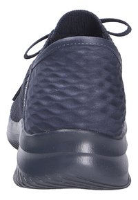 Zapatilla deportiva azul marino con parte superior de malla texturizada, talón redondeado y suela de goma maciza con ranuras sutiles para mejor tracción.