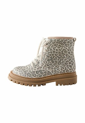 Wysokie do kostki buty sznurowane, z materiałowym wierzchem w leopardzi wzór i grubą, jasnobrązową gumową podeszwą z głębokim bieżnikiem dla przyczepności.